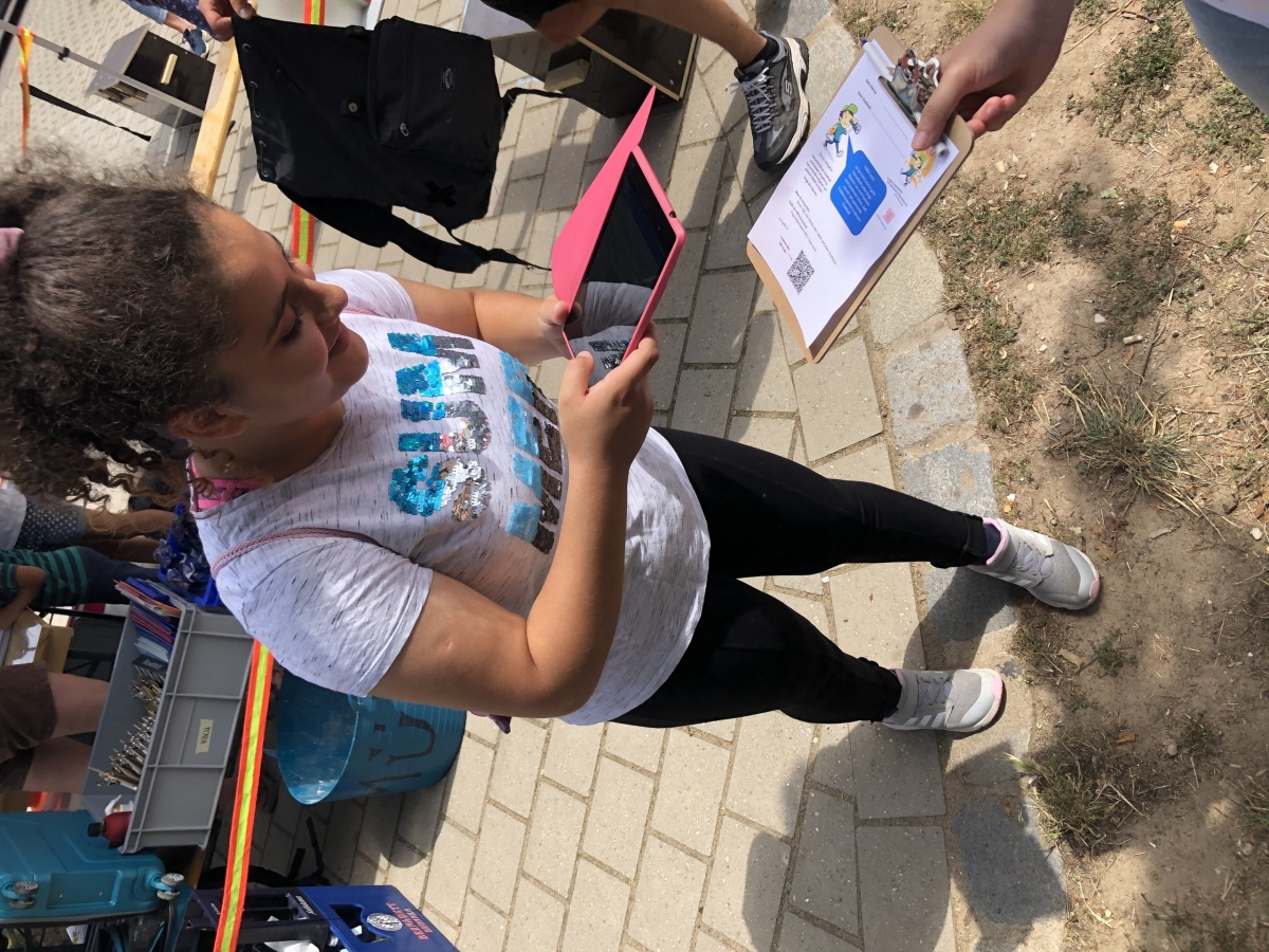 Ein Mädchen scannt mit dem Tablet einen QR-Code